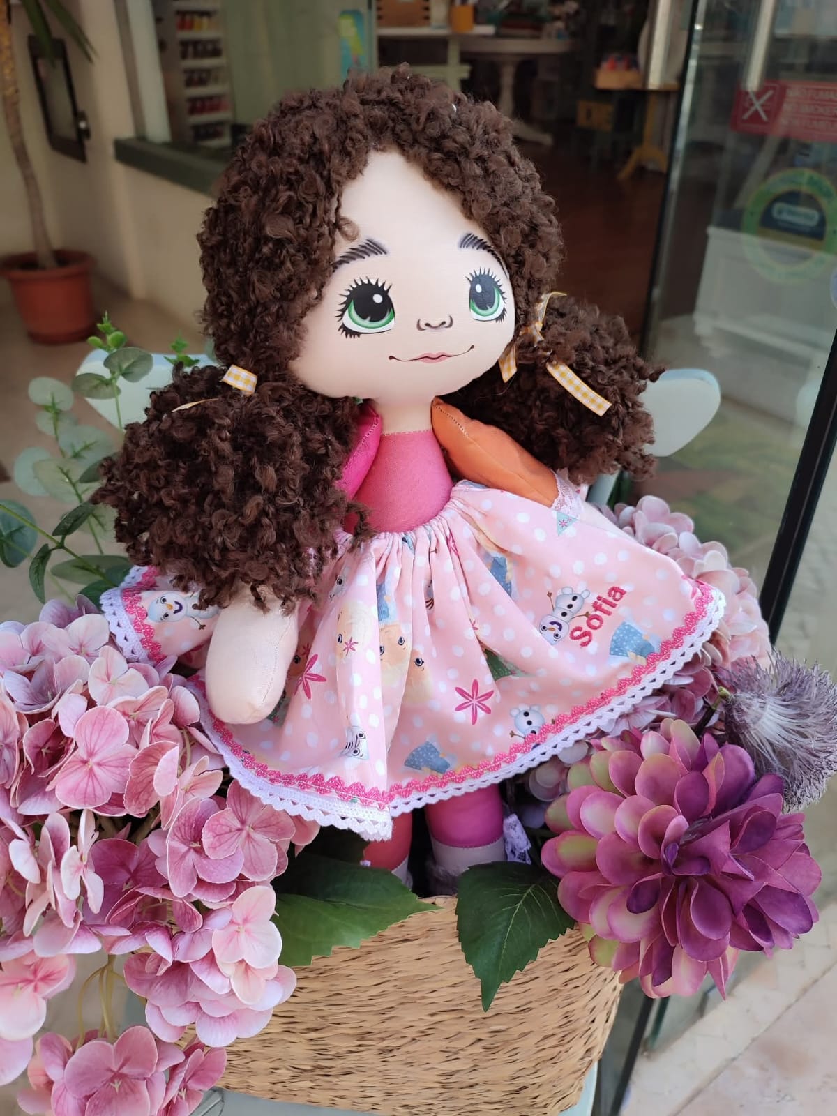 Boneca artesanal entre flores